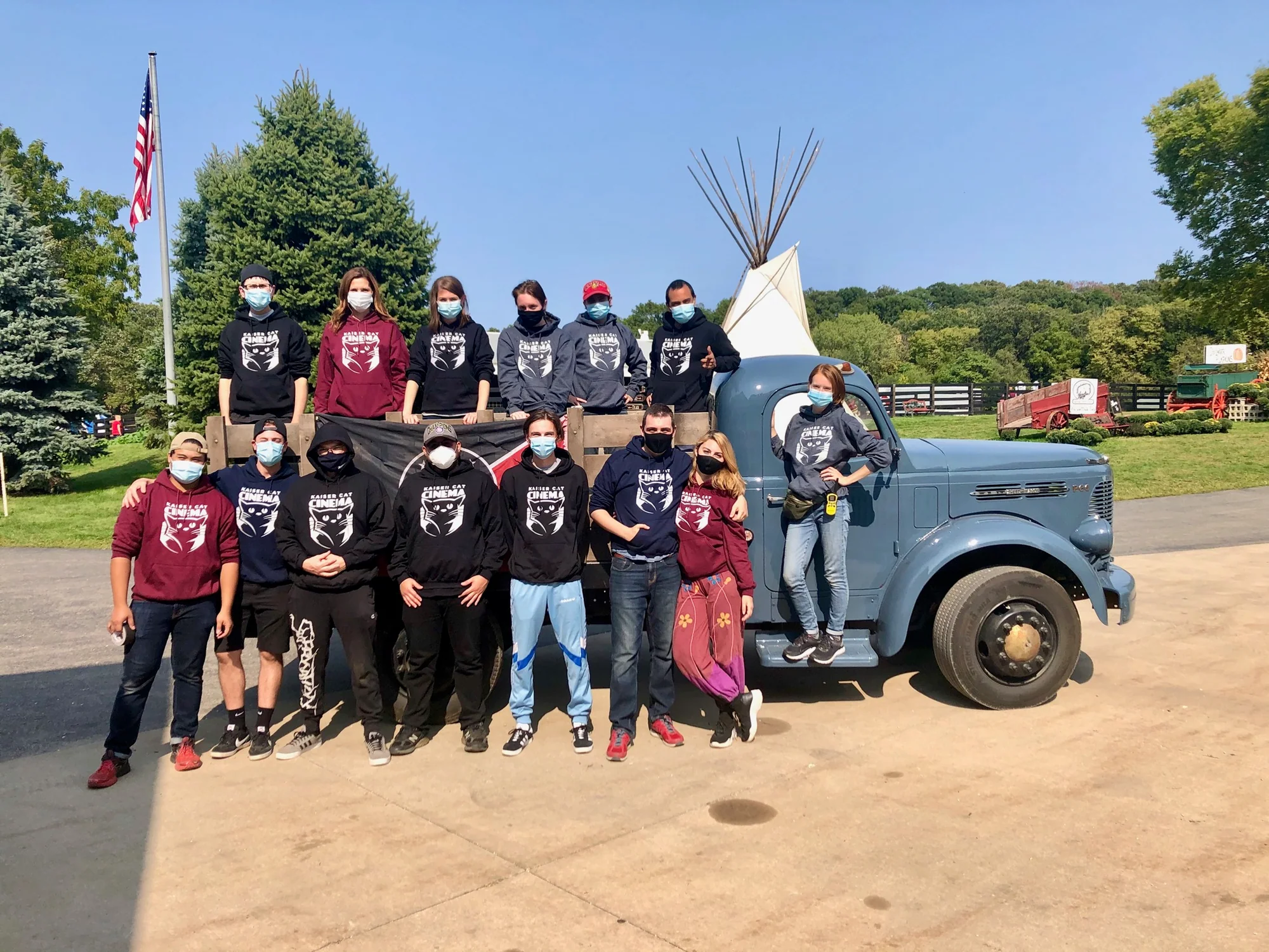 The Kaiser Cat Collective team gathered in front of a vintage truck